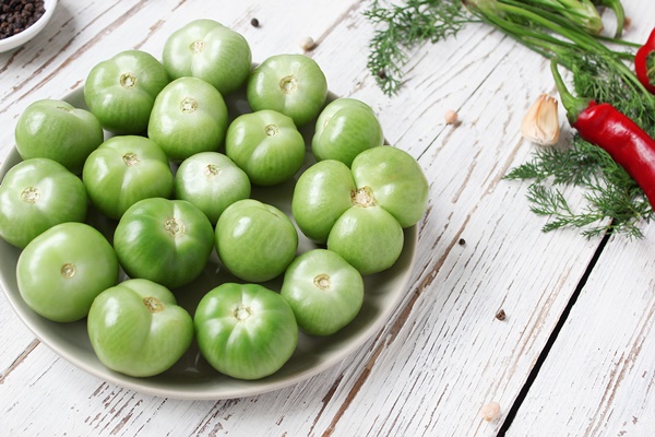 green tomatoes pickles on white wooden table with green and red and chili peppers fennel salt black peppercorns garlic pea close up healthy concept top view flat lay - Икра из перца и зелёных помидоров
