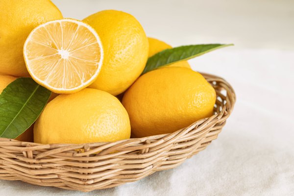 group of whole and cut organic fresh lemon in wood basket on white background - Праздничная коврижка