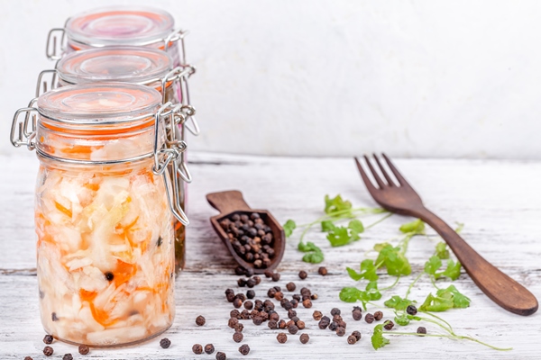 homemade marinated sauerkraut sour in glass jars rustic wooden kitchen table - Капуста белокочанная для быстрого употребления