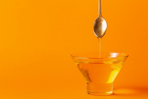 honey dripping off spoon in bowl with copy space - Торт постный