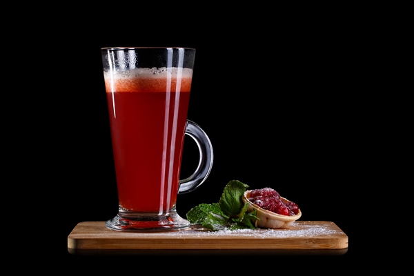 hot alcoholic cocktail of sangria and cranberry nectar decorated with honey and lingonberry jam isolated on black background - Квас из брусники