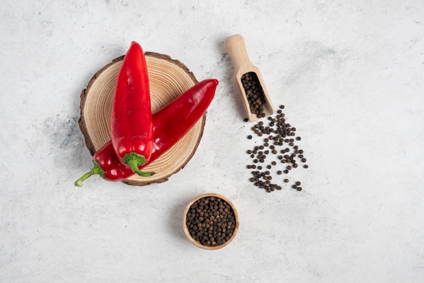 hot chili peppers and pepper grains on marble background - Икра из перца и зелёных помидоров