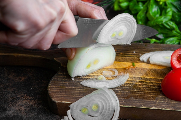 housewife cutting onion for salad on wooden board close up 1 - Салат картофельный с груздями