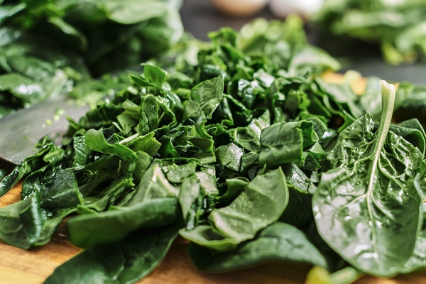 juicy green sliced spinach leaves lie on a wooden cutting board selective focus close up of spinach the idea of making breakfast from organic healthy food - Салат «Витаминный» с крапивой