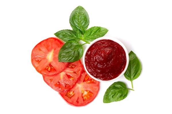 ketchup tomato paste in a saucepan with basil leaves and tomato slices on a white background - Подливка овощная постная