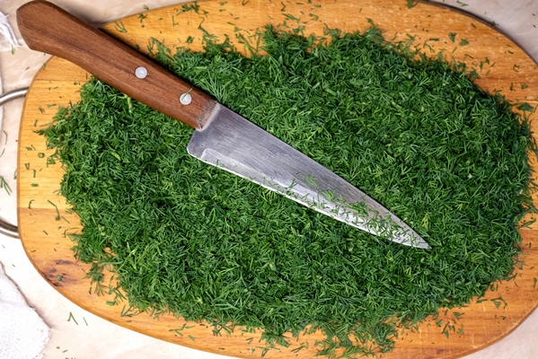lots of chopped fresh dill on wooden cutting board - Постный грибной суп с сухофруктами