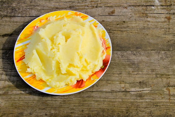 mashed potatoes in a plate on the rustic wooden table - Зразы картофельные с грибами
