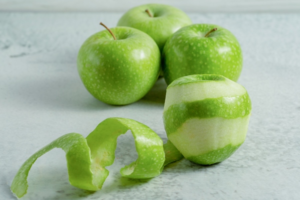 peeled and whole fresh organic green apples on grey surface - Желе яблочное
