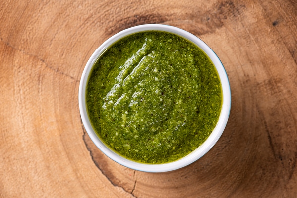 pesto sauce in a transparent glass with the ingredients in the surface olive oil garlic and basil - Крапивный соус 