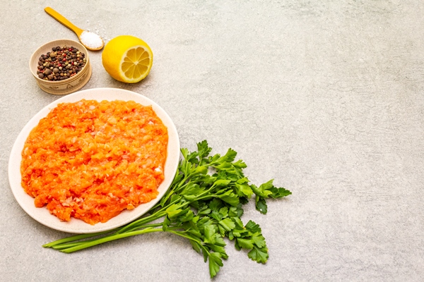 raw minced red fish stuffing on a stone surface ingredient for making fish balls casseroles terrine pate spices salt parsley lemon on a stone surface copy space - Фарш рыбный