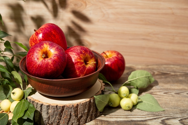 ripe red apples in a bowl and small green apples on a wooden background apple harvest concept copy space for - Яблоки с изюмом и орехами