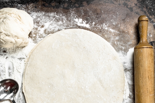 roll out dough for pizza on a rustic background - Пирог из ревеня с переплетом
