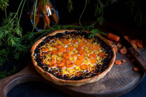 rustic pie with carrots on a dark background - Пирог морковный открытый