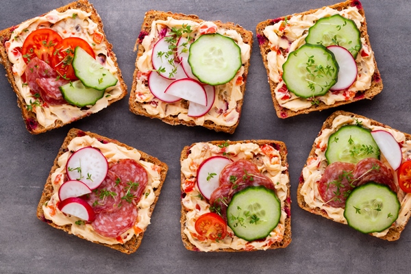 sandwiches with cream cheese vegetables and salami sandwiches with cucumber radish tomatoes salami on a gray background top view flat lay 1 - Бутерброд с колбасой и овощами