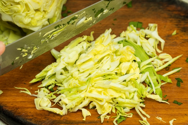 sliced cabbage shredded cabbage on the board isolated - Салат из капусты с рисом и изюмом