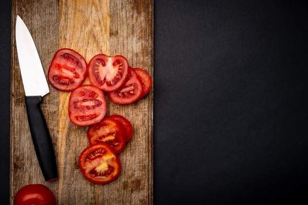 sliced cherry tomatoes with knife on wooden board on background with copyspace healthy organic pomodoro vegetable for bruschetta view from above - Салат "Осенний"