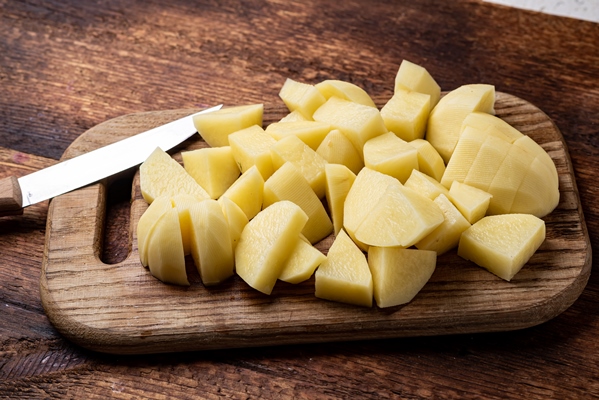 sliced raw potatoes on a wooden background preparation for cooking - Постное рагу с фасолью
