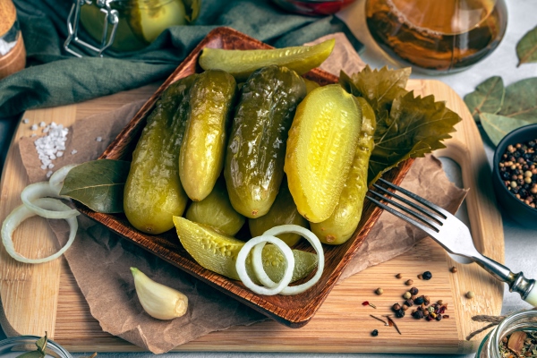 spicy pickled cucumbers with onions on a wooden cutting board on a gray background the concept of culinary backgrounds - Картофельный салат с маринованными огурцами