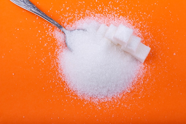 spoon and cubes of white sugar and granulated sugar on an orange background - Черносмородиновый морс