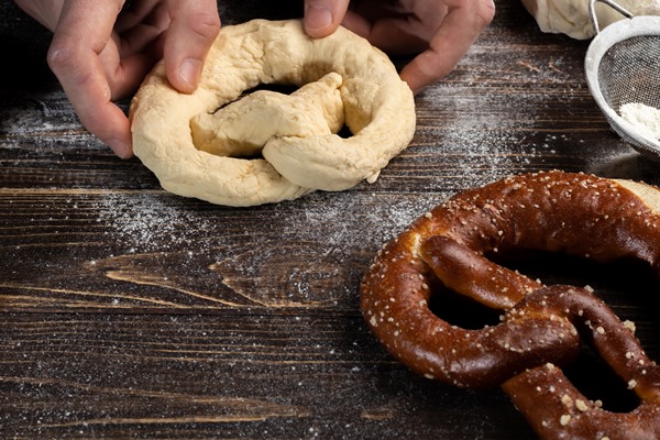 step by step instructions for making pretzels the cook rolls out the dough and rolls out the pretzel - Крендели постные