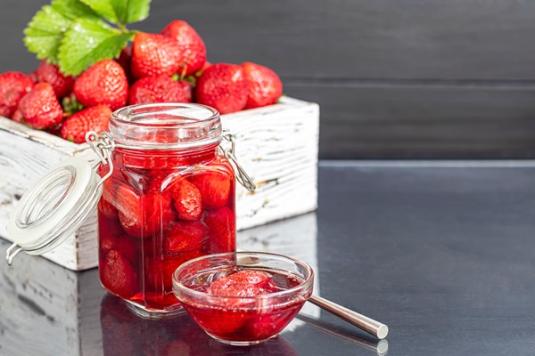 strawberry jam in a glass jar next to fresh strawberrie - Пудинг из риса с черносливом
