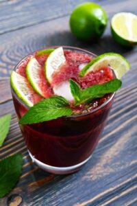 summer vitamin drink from cherry lime ice decorated with mint leaves on a wooden table berry cocktail close up vertical view - Кисель из голубики