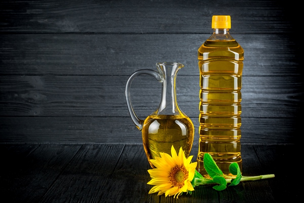 sunflower oil with flowers on black rustic background - Пюре из крапивы