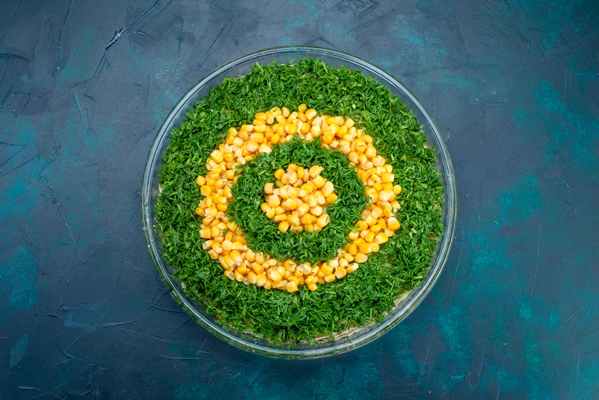 top view greens salad with corns inside round glass plate on dark blue background - Салат "Осенний"