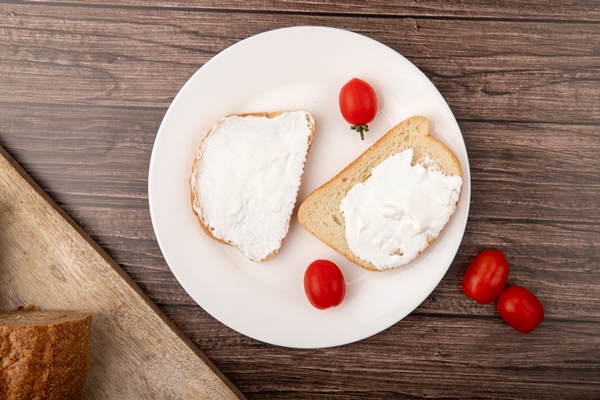 top view of plate with bread slices smeared with cottage cheese and tomatoes on wooden background - Перекус "Отличник"