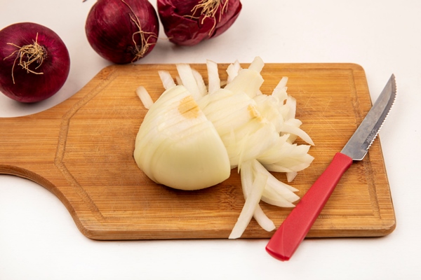top view of white onion on a wooden kitchen board with knife with red onions isolated on a white surface - Постный грибной суп с сухофруктами