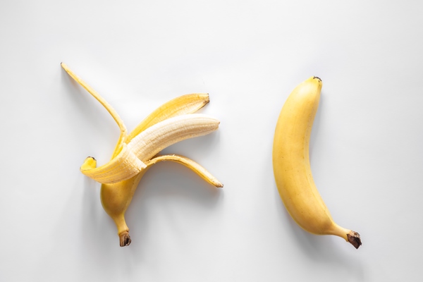 two bananas on a white background isolated conceptual minimalism - Смузи из банана и овсяных хлопьев