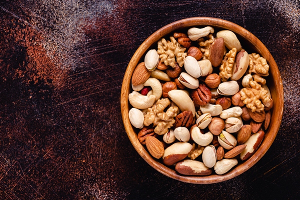 various nuts in wooden bowl - Яблоки с изюмом и орехами