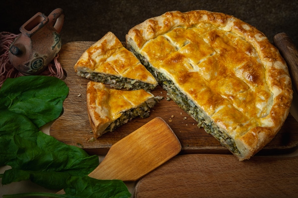vegetable pie homemade baking with spinach and onions on a dark wooden background - Пирог со щавелем закрытый