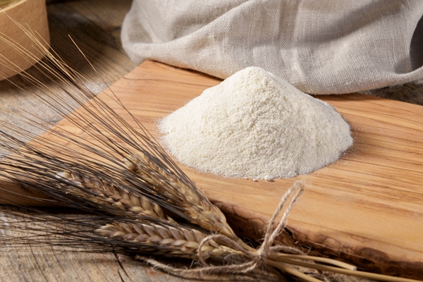 wheat flour on a wooden cutboard and spikelets on a wooden table close up - Постный суп грибной с картофелем