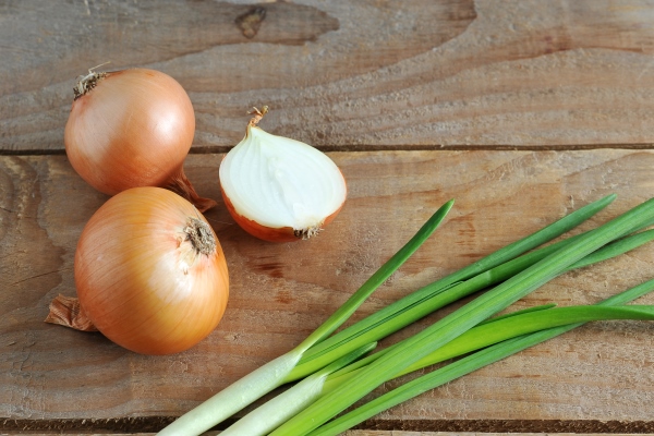 whole onions chopped and green onion on a rough wooden background - Суп весенний, постный стол