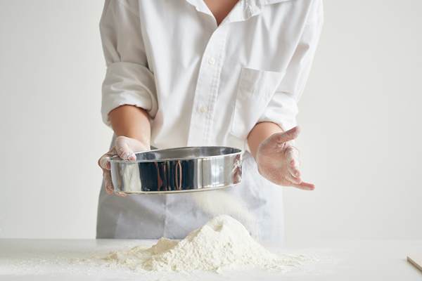 woman baker in chef uniform rolls out dough flour professional cooking - Постное тесто на дрожжах для пирожков и пирогов