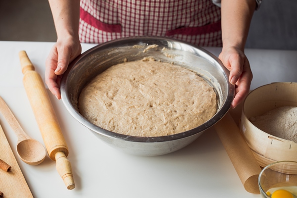 woman kneading dough on kitchen table - Пирог из гречневой каши с грибами