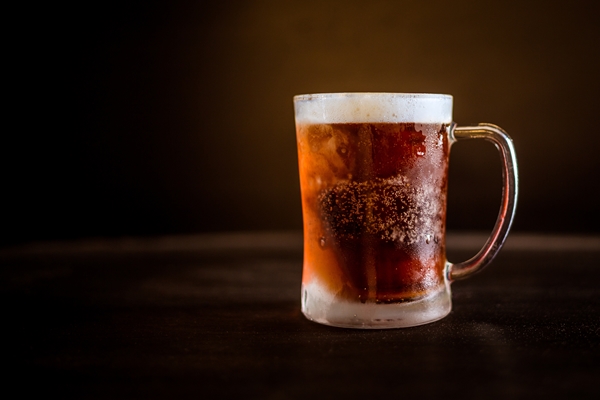 a cold glass of beer with dark brown background - Екатерининский квас