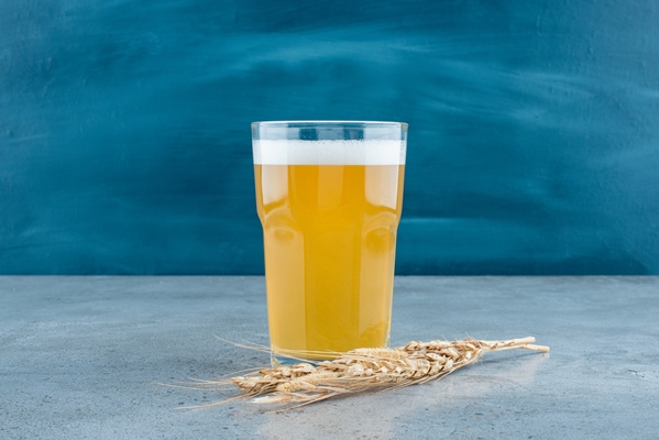 a glass of delicious beer and wheat on gray background high quality photo - Лёнечкин квас