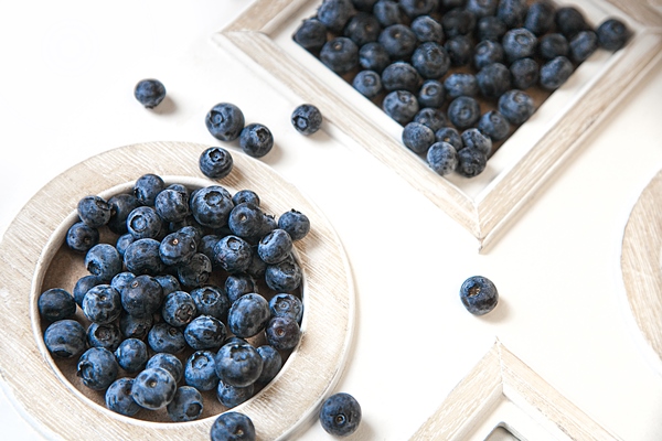 appetizing blueberries lie in white plates on a white background mockup health concept soft focus - Черника протёртая с сахаром