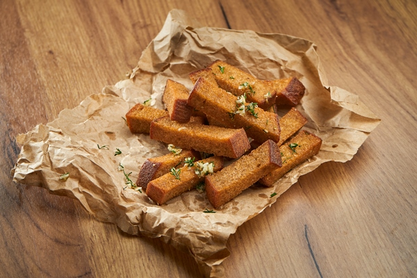 appetizing snack with beer rye croutons with garlic and herbs on parchment on a wooden surface - Гороховый суп с кабачками