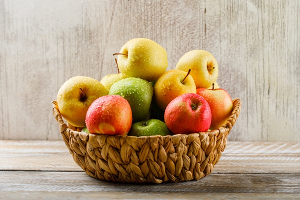 apples with drops in a wicker basket on light wooden and grunge - Черника, консервированная по-словацки