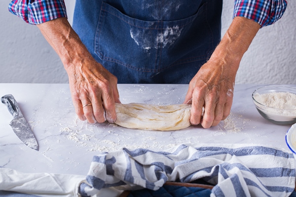 baking eating at home healthy food and lifestyle concept senior baker man cooking kneading fresh dough with hands rolling with pin spreading the filling on the pie on a kitchen table with flour 3 - Французский багет