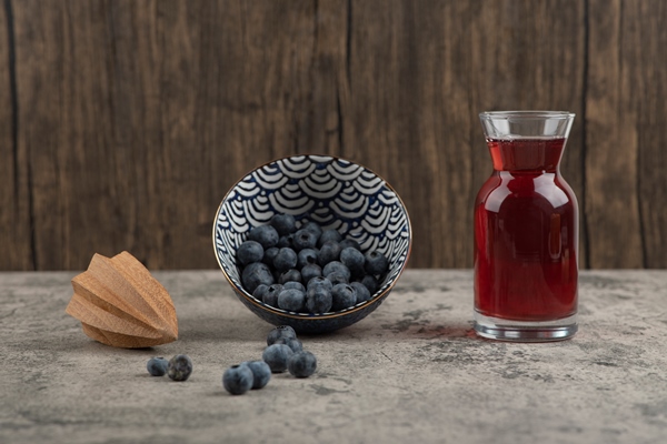 ceramic bowl of delicious fresh blueberries and glass of juice - Компот из черники и голубики
