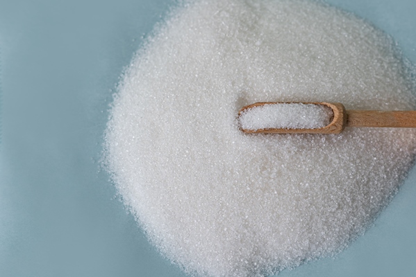 close up of granulated sugar in spoon and sugar pile - Квас с корицей (украинская кухня)