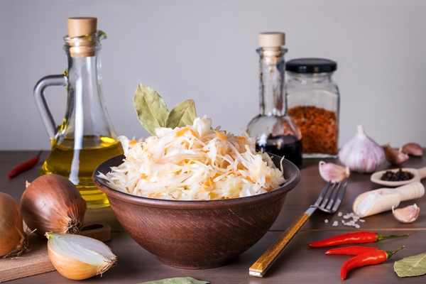 close up of sauerkraut fermented cabbage in ceramic sauerkraut bowl on table with spices and ingredients healthy healthy food russian kitchen selective focus - Щи из кислой капусты со щукой