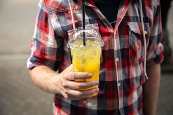 closeup a glass of lemonade in male hands - Лечебный квас