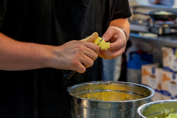 cook cutting potatoes into small pieces to make tortilla de patatas potato omelet - Манный суп