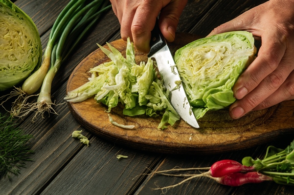 cutting fresh cabbage by chef hands before preparing national or vegetarian food peasant food - Щи с яблоками и помидорами