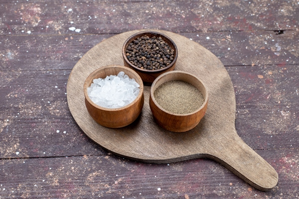 different seasonings salt pepper inside brown bowls on brown wooden rustic desk - Суп мучной